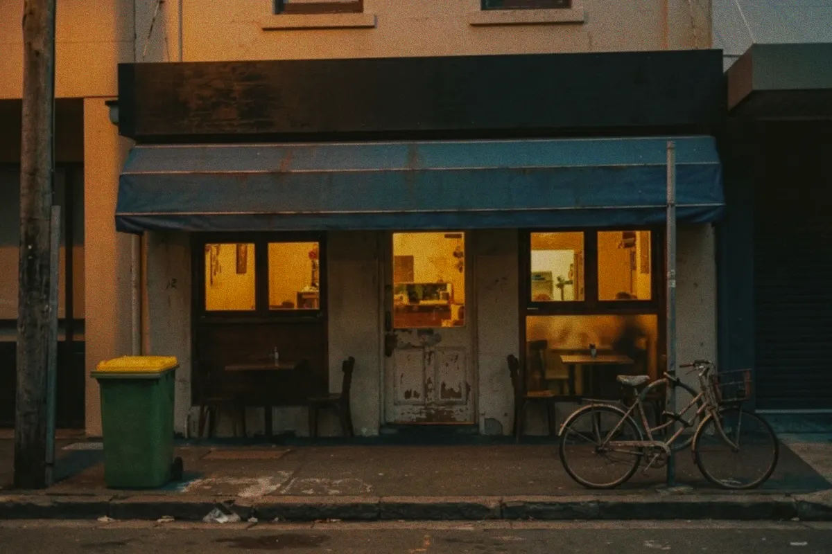 A dim phone photo of a neighbourhood café front at dusk